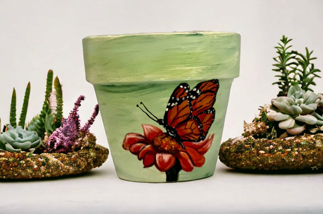 Emerald Blossoms -  A beautiful butterfly and a sunflower with green background hand-painted on a terracotta pot.
