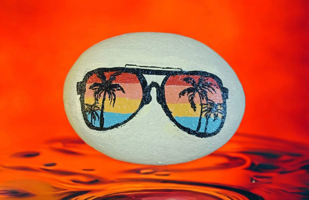 Emerald Blossoms - A creative sunglasses combined with romantic sunsets and palm trees by the beach on a hand - painted rock
